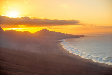 Fototapeta na wymiar Top view on Cofete beach and mountains on Jandia peninsula on Fuerteventura island on the sunset in Spain