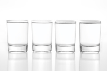 Few small shot glasses filled with alcohol on a light background