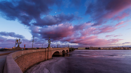 Russia, Saint-Petersburg, 19 March 2016: Pink clouds over the Troitsky Bridge at sunset, drifting ice, frozen Neva River, the traffic on the bridge, a pedestrian walk, Troitskiy © Vladimir Drozdin