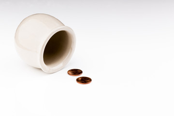 White pot on its side with few coins