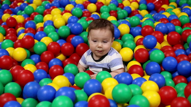 Baby play with balls in playground
