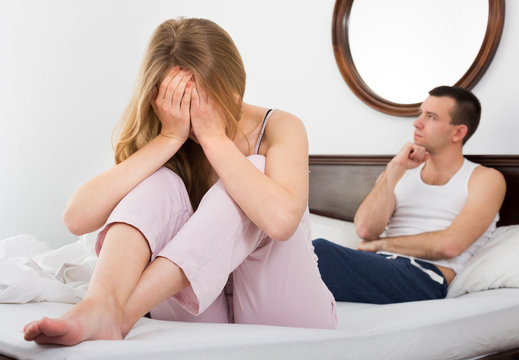 Two young partners upset in bedroom.
