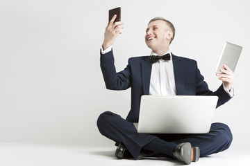 Portrait of Smiling Handsome Caucasian Man in Suit Using Digital Gadgets