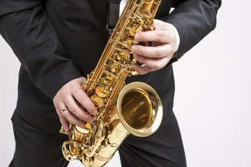 Obraz premium Mucs Concept. Closeup of Hands of Saxophone Player Playing on Saxophone