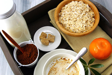 A morning breakfast tray with coffee, coffee granules, Oats,  sugar and milk.