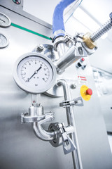 Steel pipelines and valves on trucks transport milk at factory