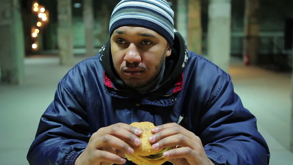 Factory worker dining after a hard day. Tasty but fatty burger. Eating fast food