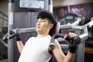 young handsome man works out in modern gym