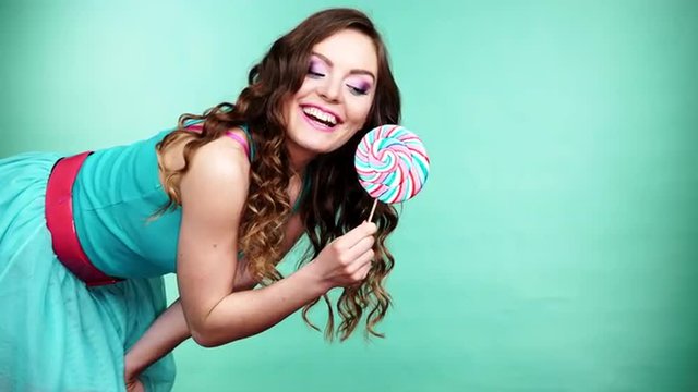 Woman smiling girl with lollipop candy on green 4K