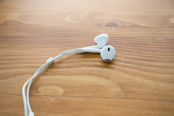 white audio earphones over wooden table