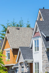 Custom built luxury house in a residential neighborhood in North America on a sunny day. Roof with windows.