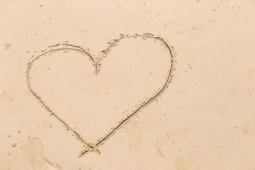 heart drawn in the smooth beach sand. love concept