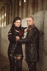 Tribal couple in leather costume with a bow inside abandoned building