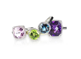 Scattered gemstone and diamond halo fine jewelry rings in a grouping