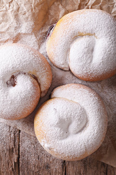 Spanish ensaimadas sweet rolls close-up on the table. vertical top view
