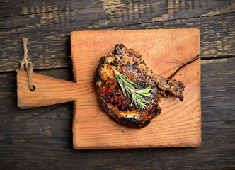 grilled steak with rosemary on a wooden background