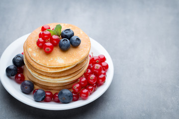 Stack of pancakes with blueberry and fresh berry.