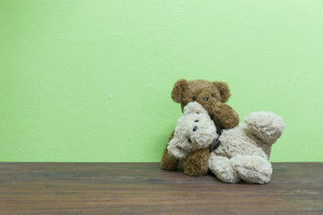 Teddy bear on old wood in front  green background.