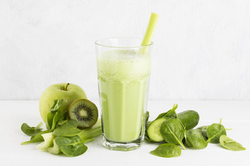 Ingredients for smoothie: spinach, kiwi, apple, celery on a whit
