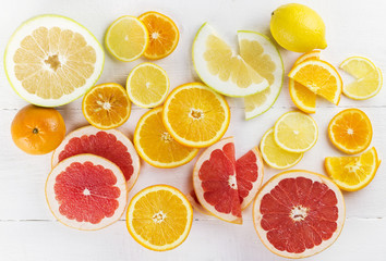 Various citrus on white wooden background