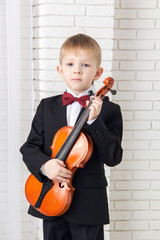 little boy in a suit standing with violin