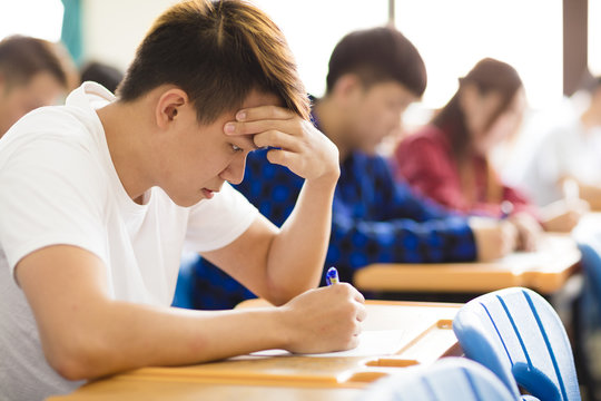 Stressed College Student  For Exam In Classroom