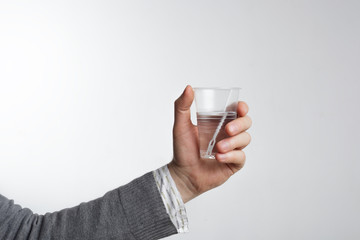 Man holding a disposable plastic cup with water. The lack of dri