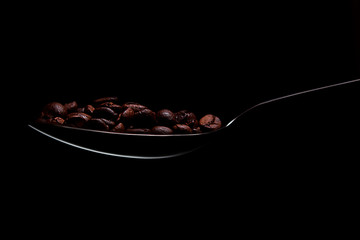 Löffel mit Kaffeebohnen schwarzer hintergrund