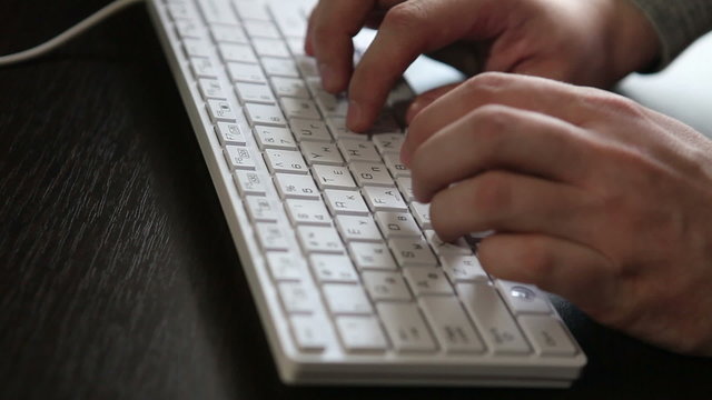 male hands typing on the keyboard, close-up