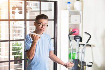 Fototapeta na wymiar asian senior male with dumbell in the gym
