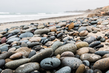 Close-up view of stones scattered about the beach at South Carlsbad State Beach in San Diego, California.