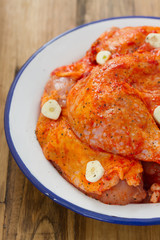 chicken in sauce with garlic in dish on brown background