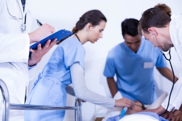 Doctor writing on clipboard