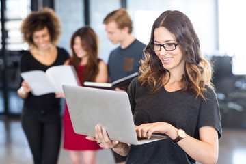 Businesswoman using laptop and smiling