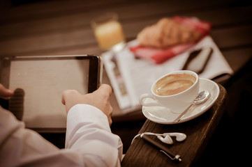 Young Man Eating Breakfast Whilst Using Tablet