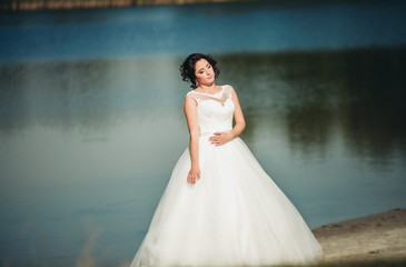 Fototapeta na wymiar Beautiful luxury bride posing with a bouquet outdoors 