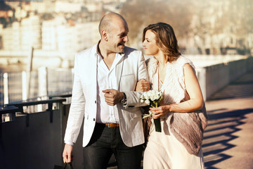 happy stylish bride and groom walking on a sunny day in Lion on