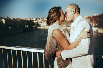 stylish beautiful rich bride and groom kissing on a sunny day on