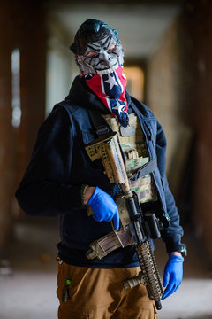 Photo of man wearing mask with gun/Man in scarry mask, blue gloves, bandana with gun in his hand