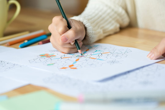 Close-up image of woman drawing geometric figures