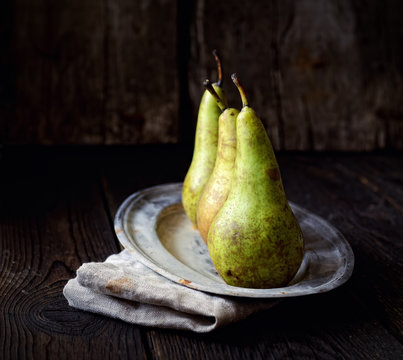 pears on a plate on a wooden background
