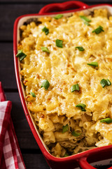 Casserole with pasta and white cabbage on a black wood background 