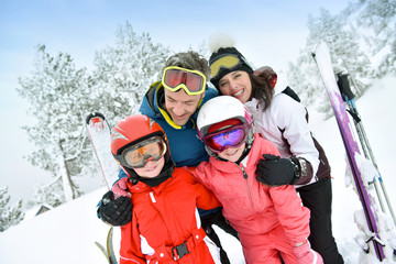 Portrait of happy family of skiers in snowy mountain