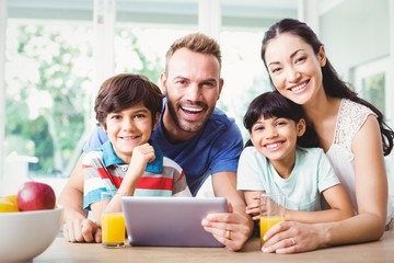 Portrait of smiling family using digital tablet 