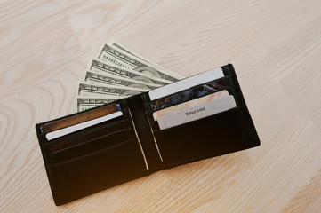 Dollars with credit cards in the black leather wallet