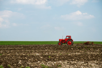 Obraz premium red tractor in the agricultural field