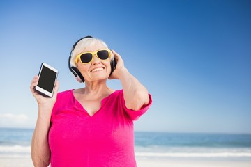 Senior woman listening music with headphone