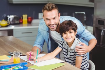 Portrait of father assisting boy in solving maths 