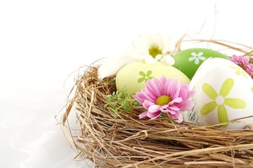 Fototapeta na wymiar Cropped shot of easter eggs in the nest with flowers isolated