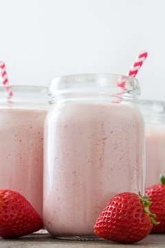 Delicious strawberry smoothie on rustic wood
